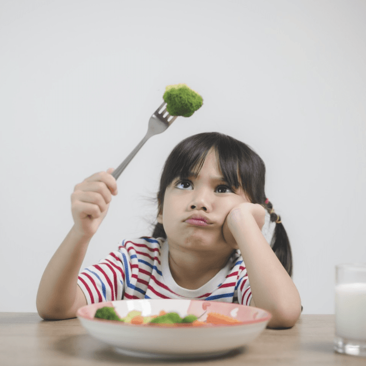 Girl eating broccoli