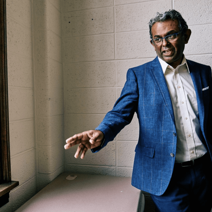 Man in a blue suit in cinder block room